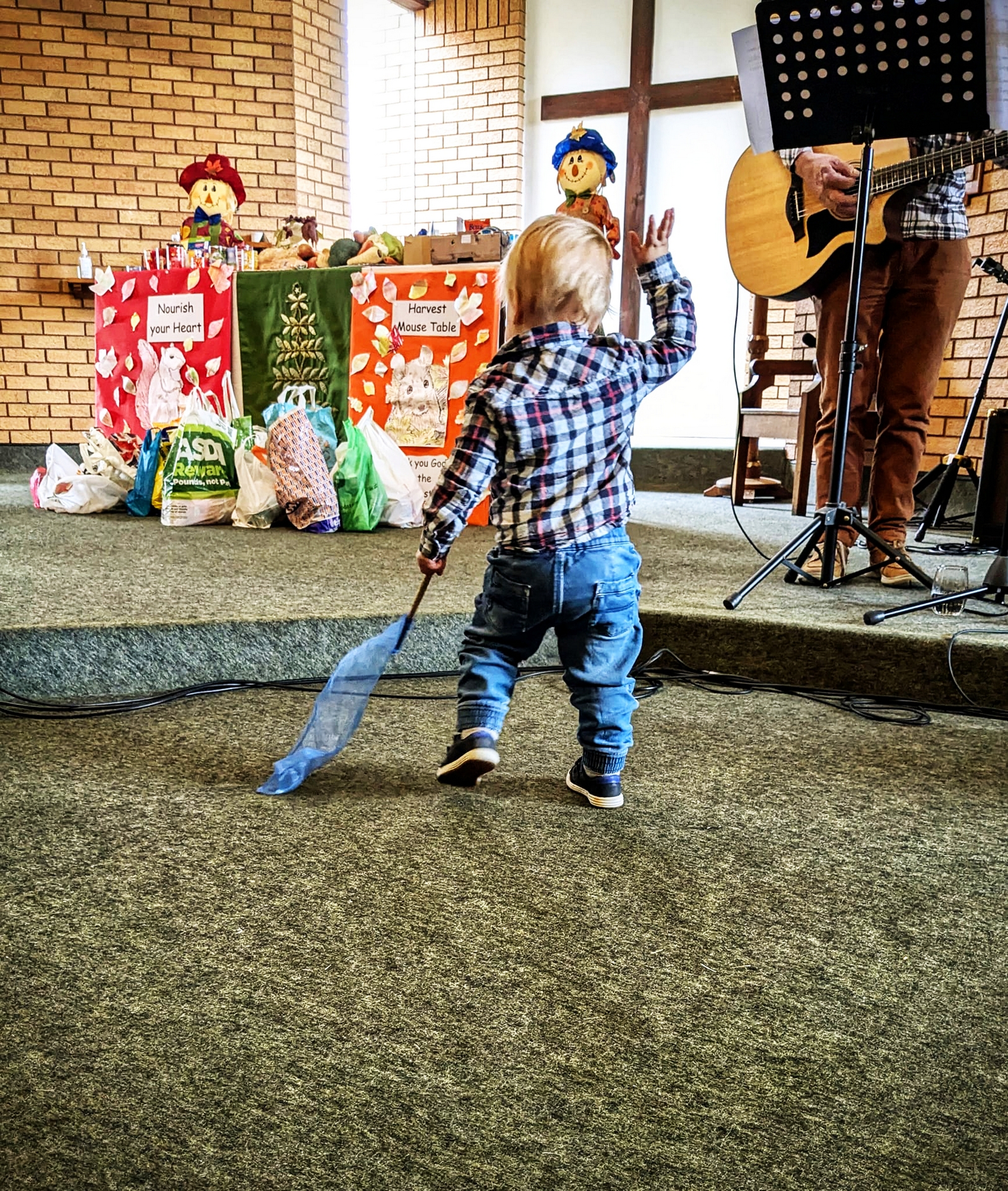 A young child worshipping with hand in the air and flag